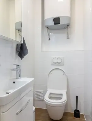 a white bathroom with a toilet and a sink at yubc in Novi Beograd