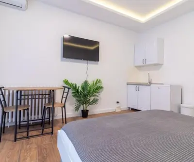 a bedroom with a bed and a table and a kitchen at yubc in Novi Beograd
