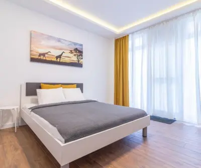 a bedroom with a bed and a large window at yubc in Novi Beograd