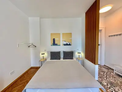 a large bed in a room with two lamps at Apartment 5A - Experience true Belgrade! in Belgrade