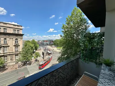 a balcony with a red bus on a city street at Apartment 5A - Experience true Belgrade! in Belgrade
