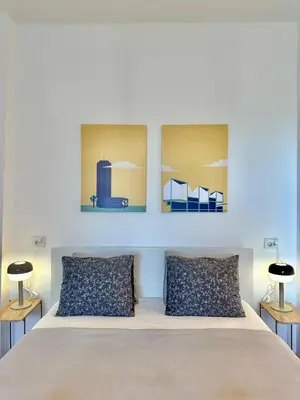 a bedroom with a bed with two paintings on the wall at Apartment 5A - Experience true Belgrade! in Belgrade