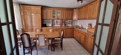 a kitchen with wooden cabinets and a table and chairs at Beautiful large villa Vrčin in Vrčin