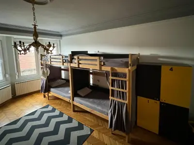 a room with two bunk beds and a chandelier at Nomad Hostel in Belgrade
