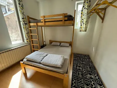 a bedroom with a bunk bed and a ladder at Nomad Hostel in Belgrade