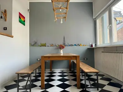 a table and two chairs in a room with a checkered floor at Nomad Hostel in Belgrade