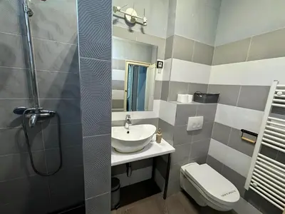 a bathroom with a sink and a shower and a toilet at Nomad Hostel in Belgrade