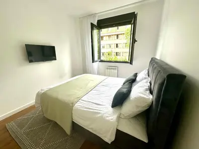 a bedroom with a large bed with a window at Luxury new apartment in Belgrade in Belgrade