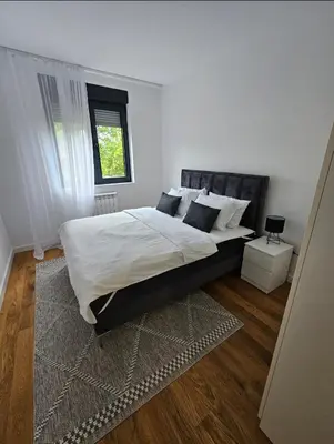 a bedroom with a large bed with white sheets and pillows at Luxury new apartment in Belgrade in Belgrade