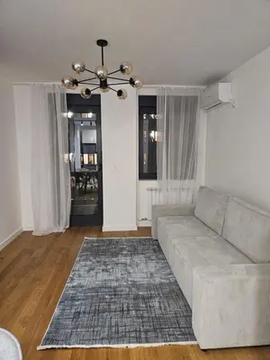 a living room with a couch and a chandelier at Luxury new apartment in Belgrade in Belgrade
