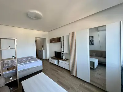 a bedroom with a bed and a living room at MaKi apartment in Belgrade