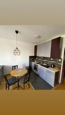 a kitchen with a table and a table and a dining room at Studio Charlie Aviv Park in Mirijevo