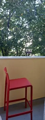a red bench sitting in front of a window at Apartment ADA RB Belgrade in Čukarica