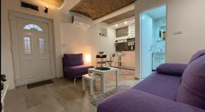 a living room with a purple couch and a table at Uno in Belgrade