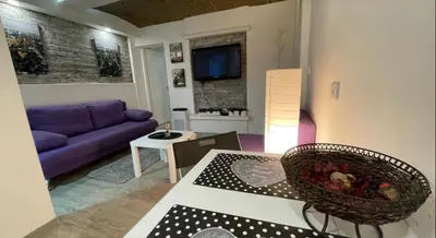 a living room with a purple couch and a table at Uno in Belgrade