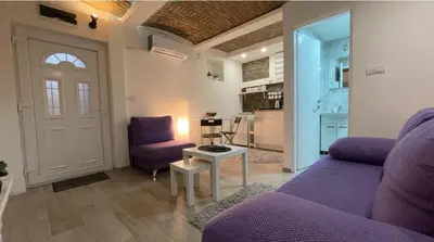 a living room with a purple couch and a table at Uno in Belgrade