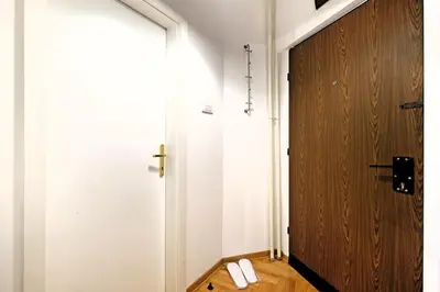a hallway with a wooden door and a cross on the wall at Downtown nest Apartment in Belgrade