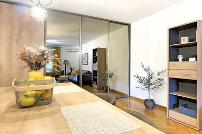 a dining room with a table and a living room at Downtown nest Apartment in Belgrade