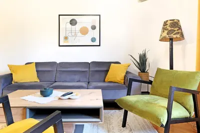 a living room with a blue couch and yellow pillows at Downtown nest Apartment in Belgrade