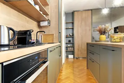 a kitchen with black appliances and a wooden floor at Downtown nest Apartment in Belgrade