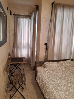 a bedroom with a bed and a table and a window at Retro studio in Zemun