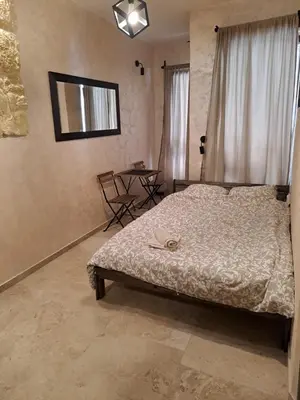 a bedroom with a bed and a table with chairs at Retro studio in Zemun