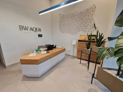an office with a reception desk and potted plants at Aqua Royal BW studio in Sajmište