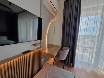 a hotel room with a desk and a large window at Aqua Royal BW studio in Sajmište