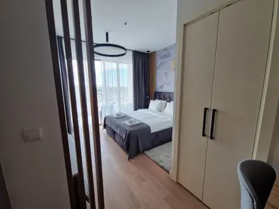 a bedroom with a bed and a large window at Aqua Royal BW studio in Sajmište