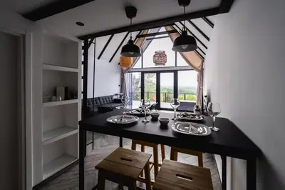 a dining room with a table and chairs and a window at Ruža vetrova in Mislođin