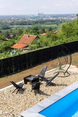 two chairs and a table next to a swimming pool at Ruža vetrova in Mislođin