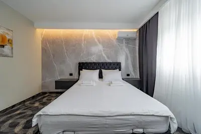 a bedroom with a large bed with white sheets at Forty One Suites Belgrade Apartments in Voždovac