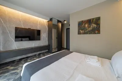 a bedroom with a bed and a tv on a wall at Forty One Suites Belgrade Apartments in Voždovac