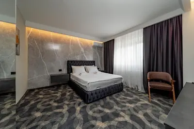 a hotel room with a bed and a chair at Forty One Suites Belgrade Apartments in Voždovac
