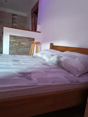 a bed with purple sheets and pillows on it at Kutak-Corner in Vračar (historical)