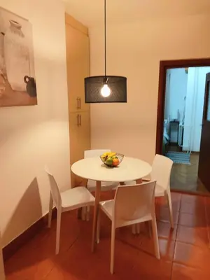 a dining room table with chairs and a bowl of fruit on it at DukeStepa in Belgrade