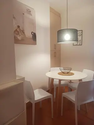 a dining room with a table and white chairs at DukeStepa in Belgrade