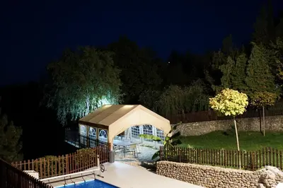 a gazebo next to a pool at night at LipaHill SPA in Ripanj