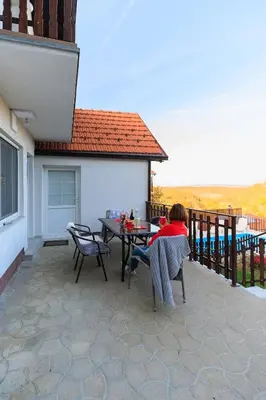 a person sitting at a table on a patio at LipaHill SPA in Ripanj