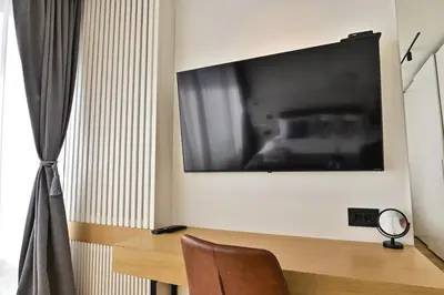 a room with a television on a wall with a chair at Belgrade City Escape - Genex in Belgrade
