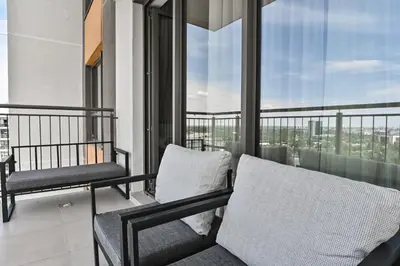 a balcony with two chairs and a view of the city at Belgrade City Escape - Belgrade Waterfront BW Aqua in Belgrade