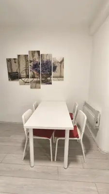 a white table and chairs in a room with paintings at B sweet home S in Belgrade