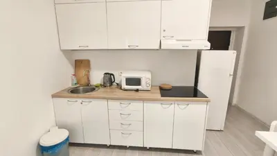 a kitchen with white cabinets and a sink and a microwave at B sweet home S in Belgrade
