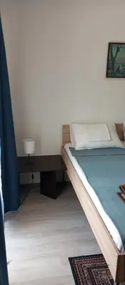 a bedroom with a bed and a table with a lamp at Airport MD Apartment in Belgrade