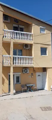 a building with two chairs and a table in front of it at Airport MD Apartment in Belgrade