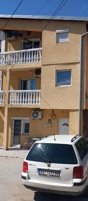a white car parked in front of a building at Airport MD Apartment in Belgrade