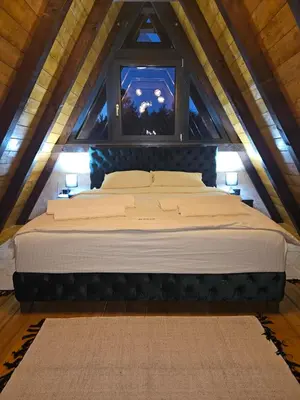 a large bed in a attic with a window at Navas River House in Poljane