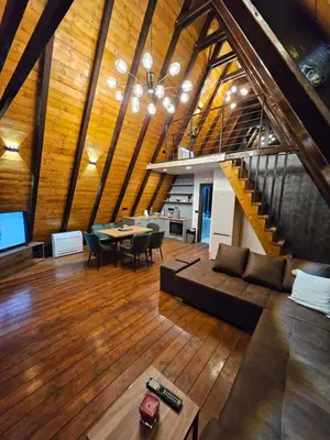 a living room with a couch and a dining room at Navas River House in Poljane