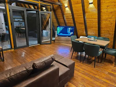 a living room with a couch and a table and a tv at Navas River House in Poljane