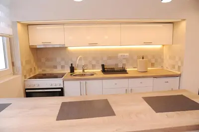 a kitchen with white cabinets and a sink at 404 Apartment in Belgrade